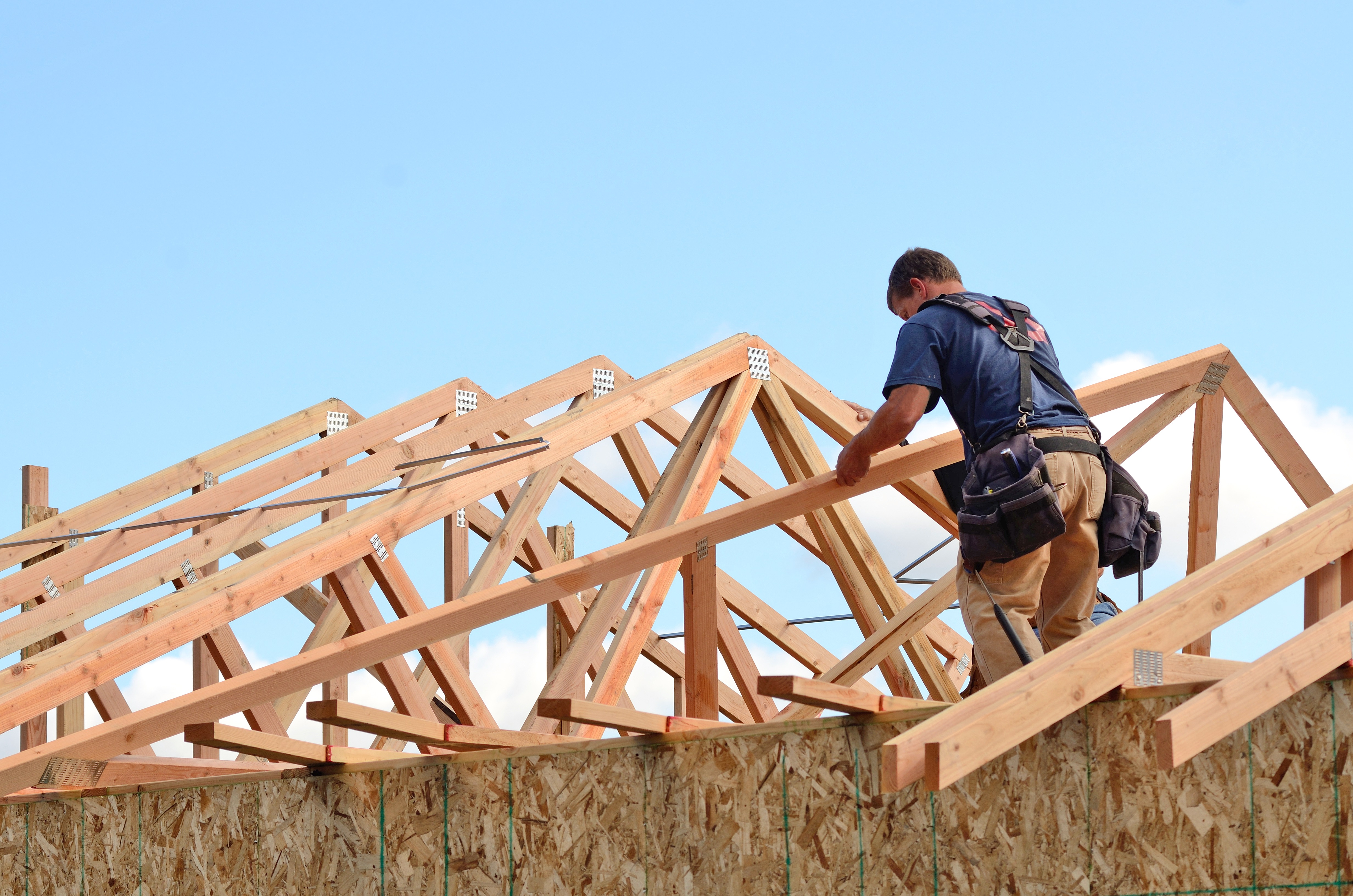 Construction worker piecing together a house frame
