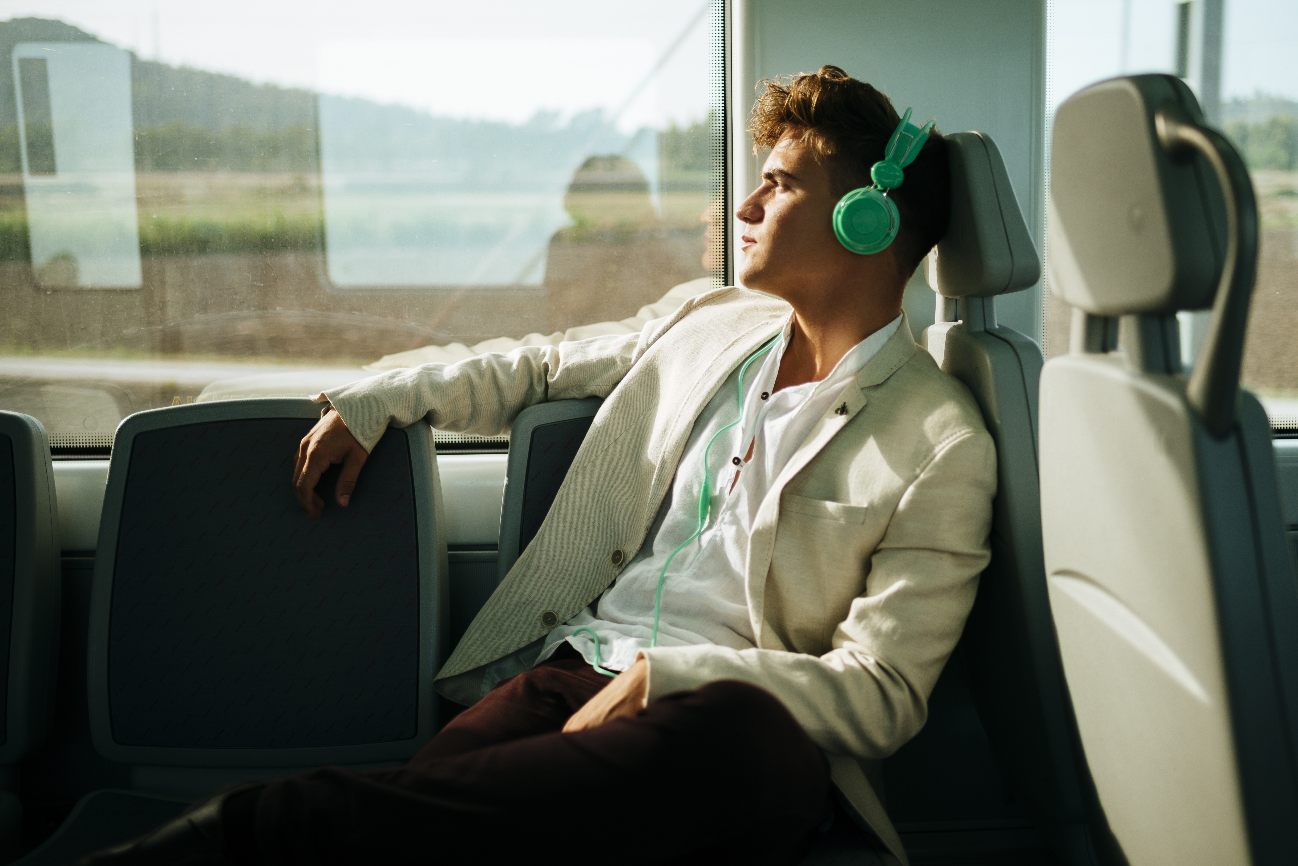 Young man listening to music on a train