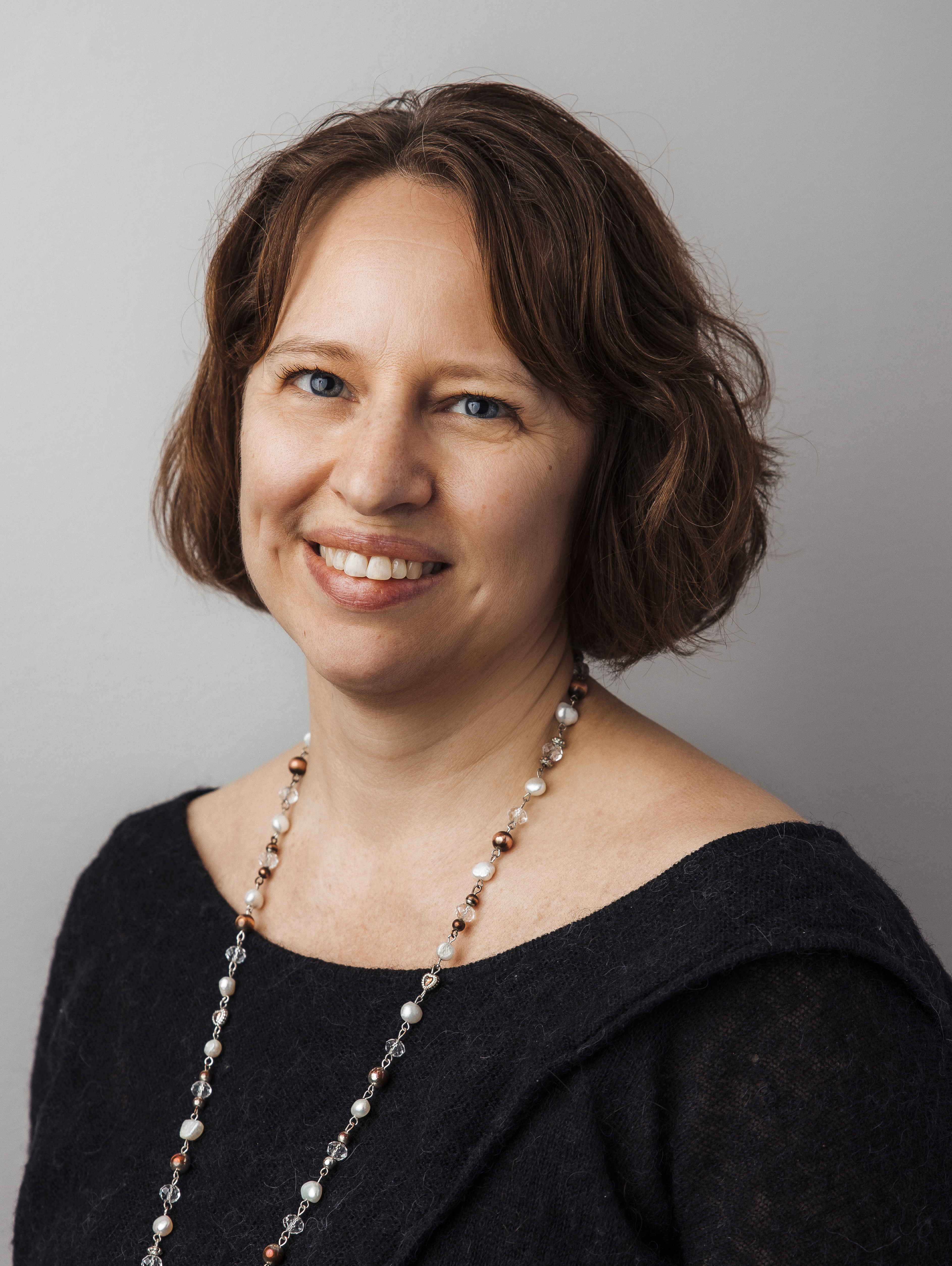 Professional headshot of Helena Vilcans with background representing public sector innovation.