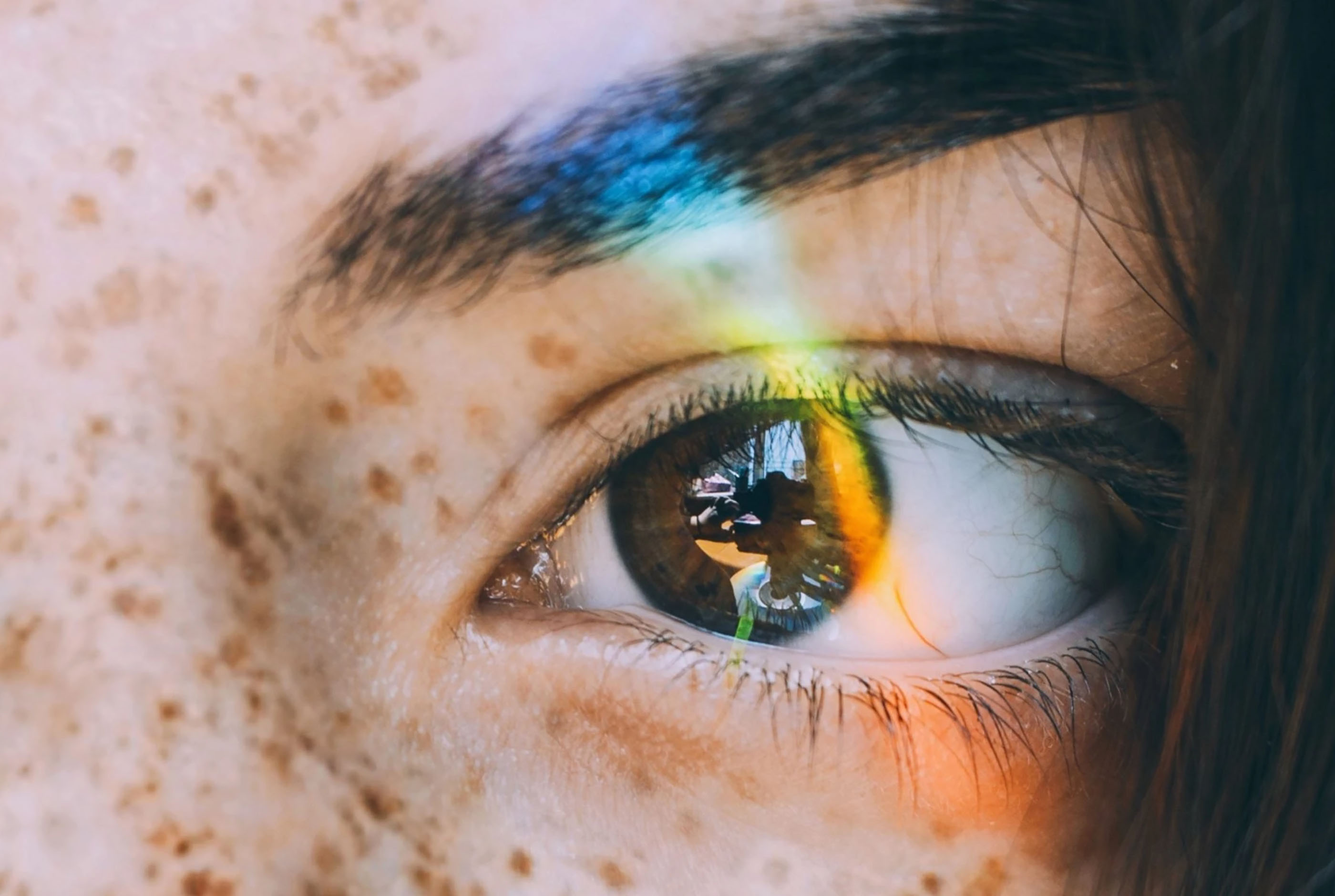 Close-up van een gezicht, met de focus op één oog en een wenkbrauw.