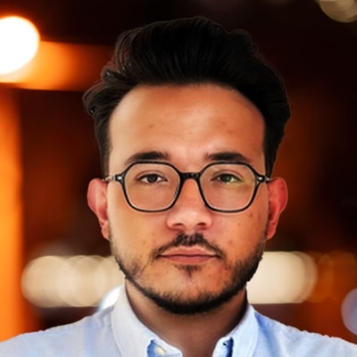 Portret van Yunus Ceyhan, een professional bij Capgemini, gekleed in een net pak en glimlachend naar de camera.
