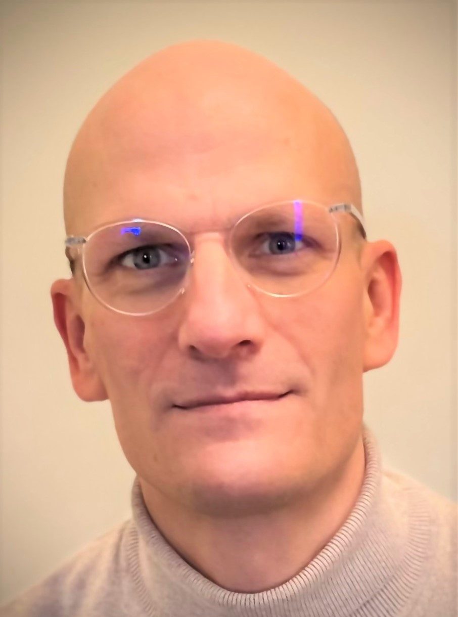 Person with glasses on and no hair.