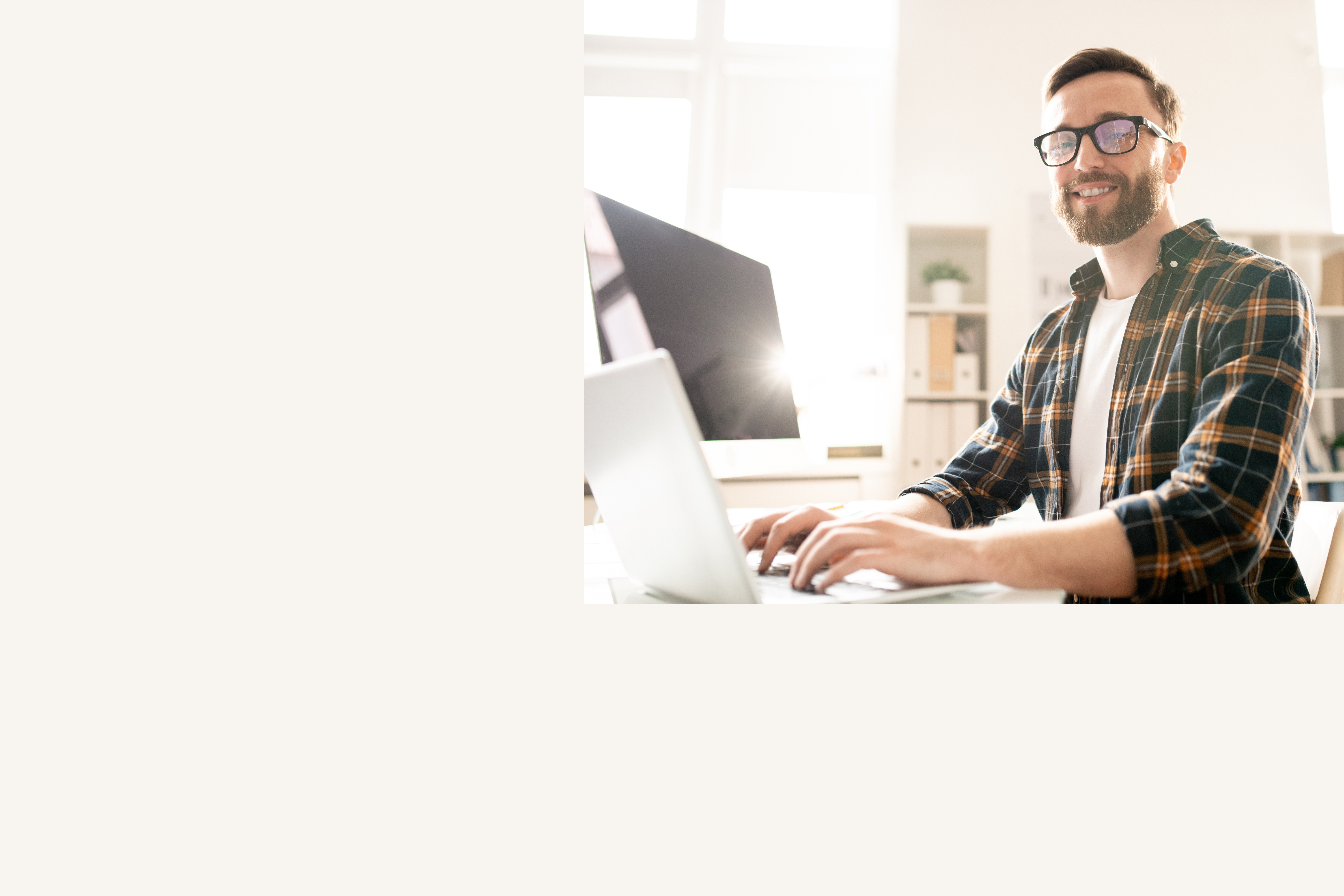 uśmiechnięty mężczynza piszący na laptopie