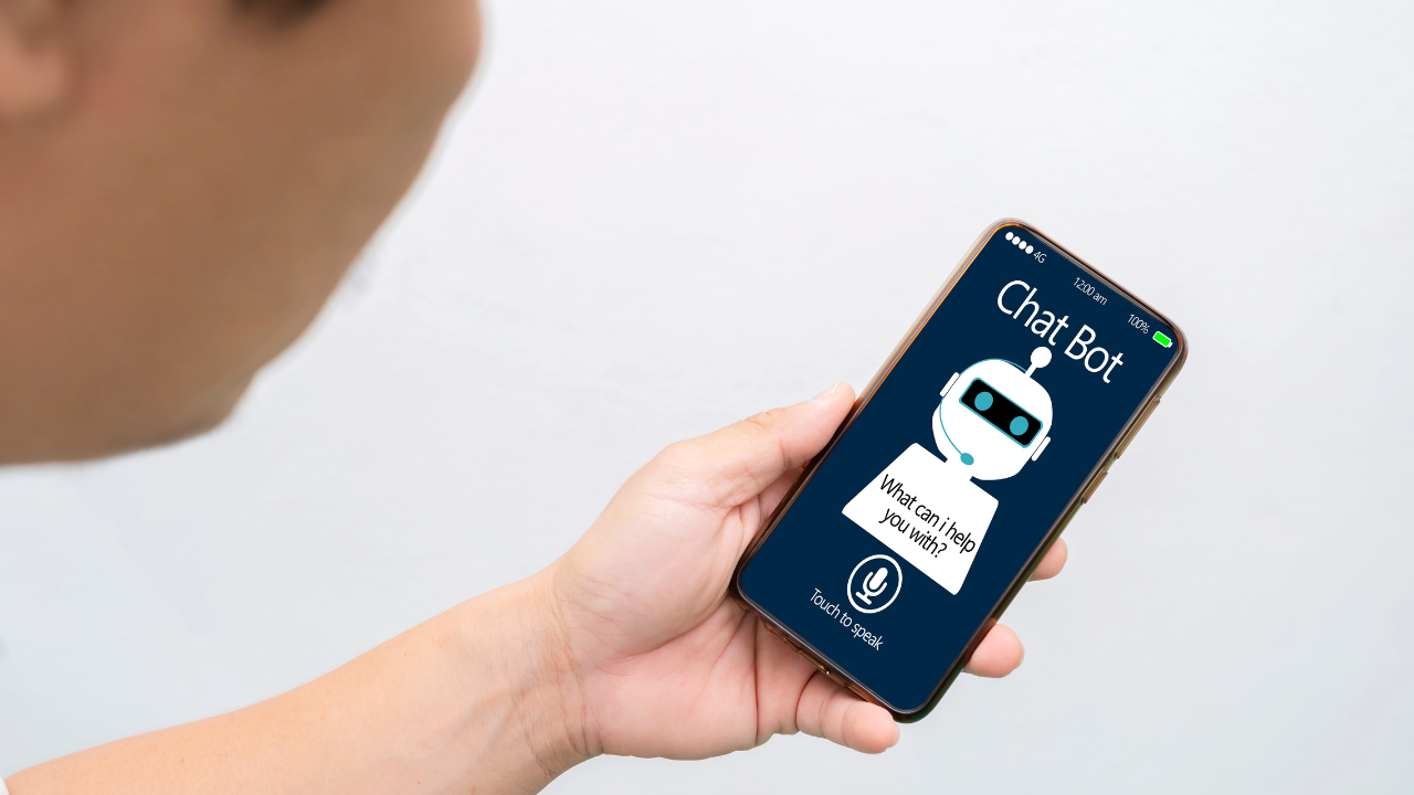ręka trzyma telefon z grafiką robota
