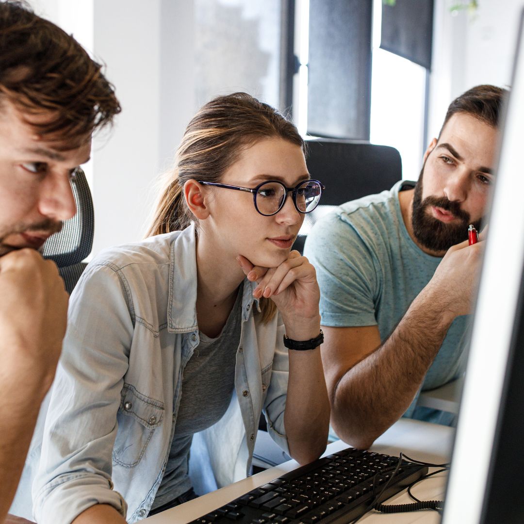 trzy osoby pracujące prze komputerem