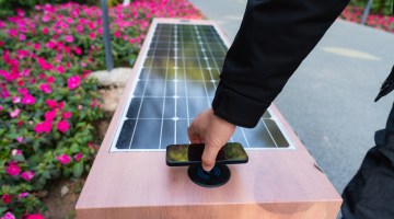 Man using solar powered seat with wireless charging function