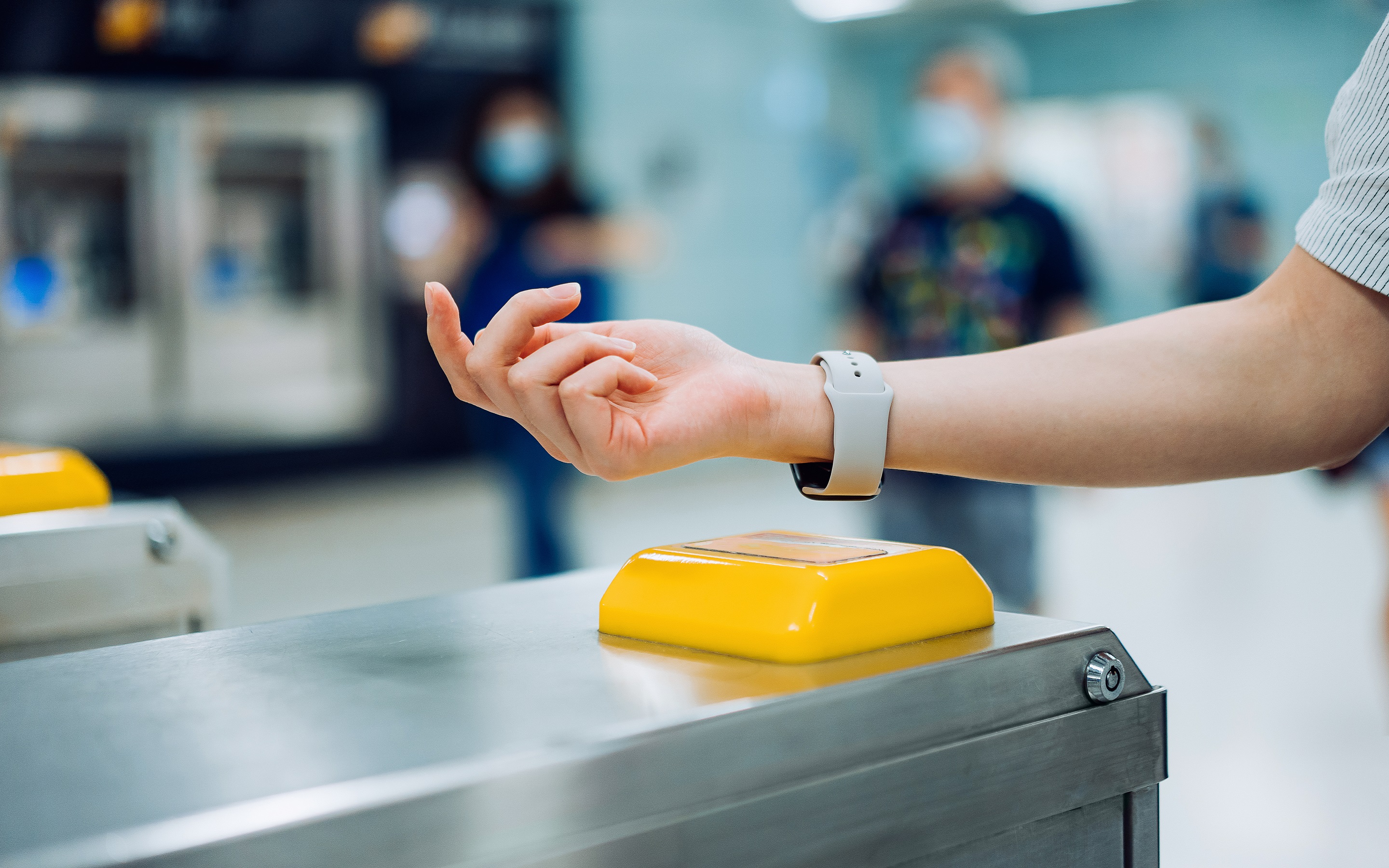 Cropped shot of young Asian woman checking in at subway station using contactless payment for subway ticket via smartwatch